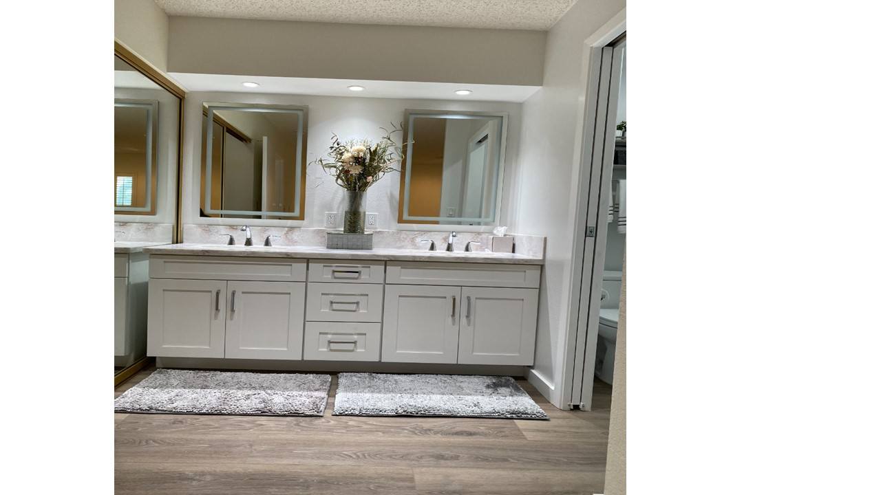 A bathroom with a vanity and a mirror above it.